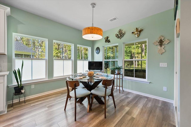 dining space with light wood-type flooring and a healthy amount of sunlight