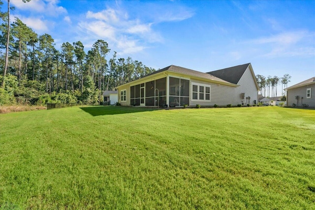 back of house with a lawn and a sunroom