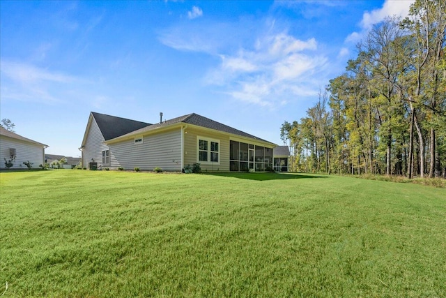 rear view of property featuring a sunroom and a yard