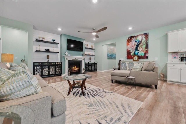 living room featuring ceiling fan and light hardwood / wood-style floors