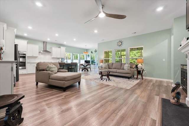 living room featuring ceiling fan and light hardwood / wood-style flooring