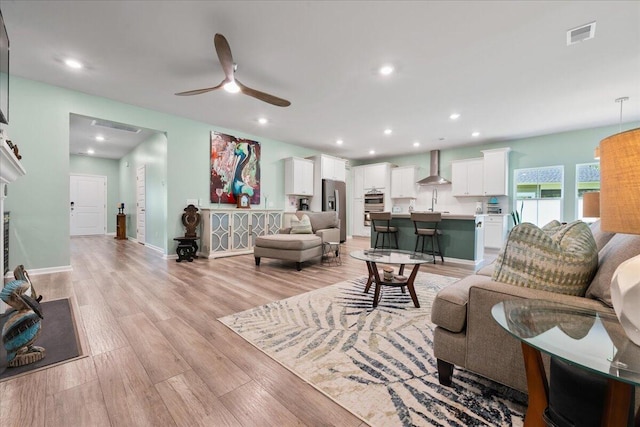 living room featuring light hardwood / wood-style flooring and ceiling fan