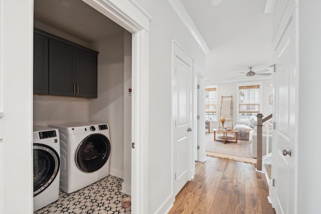 laundry room with cabinets, ceiling fan, light hardwood / wood-style flooring, washer and clothes dryer, and crown molding