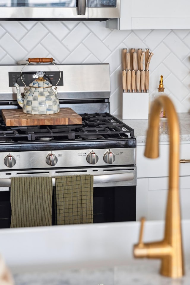 kitchen with stainless steel range with gas stovetop and decorative backsplash