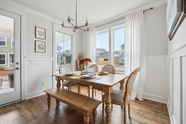 dining space featuring dark hardwood / wood-style flooring, crown molding, and a notable chandelier