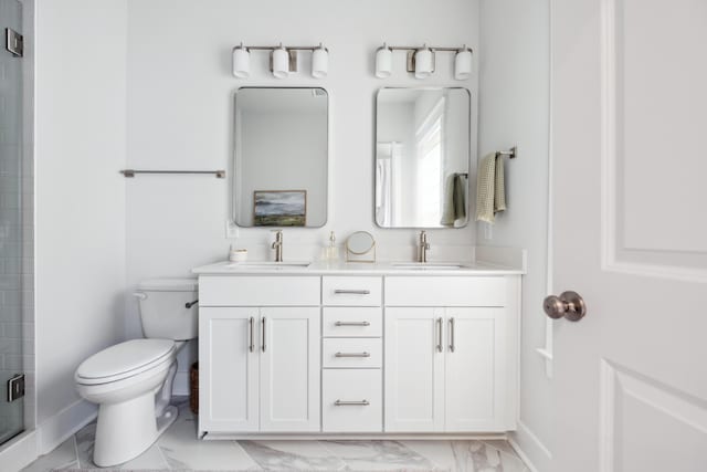 bathroom featuring toilet, a shower with door, and vanity