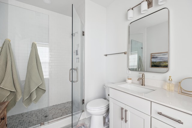 bathroom featuring toilet, walk in shower, and vanity