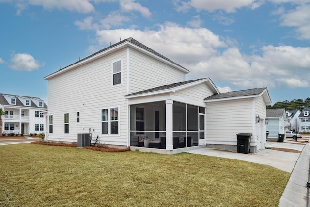 back of house featuring central air condition unit, a lawn, a sunroom, and a garage