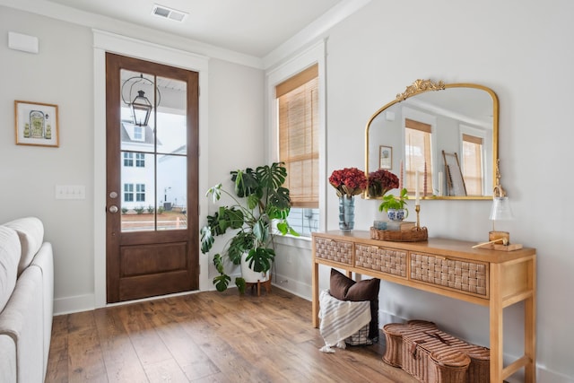 entrance foyer featuring ornamental molding and wood-type flooring