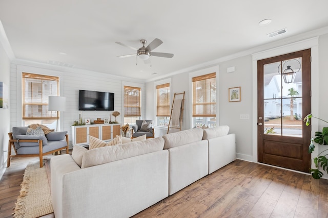 living room with ceiling fan, ornamental molding, and wood-type flooring