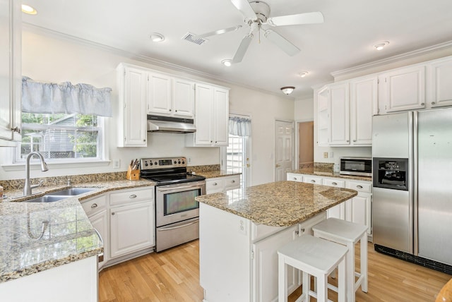 174 Revetment Ln, Mount Pleasant, SC 29464 - kitchen with appliances with stainless steel finishes, under cabinet range hood, a sink, ornamental molding, and white cabinetry