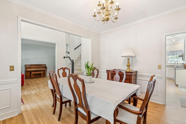 174 Revetment Ln, Mount Pleasant, SC 29464 - dining room with stairs, a chandelier, light wood-style floors, crown molding, and a wainscoted wall