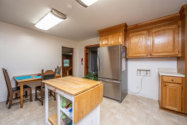 2567 Mona Ave, Charleston, SC 29414 - kitchen with freestanding refrigerator, light flooring, butcher block countertops, open shelves, and brown cabinetry