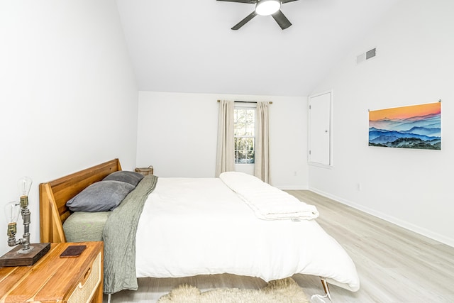 bedroom featuring light wood-type flooring, vaulted ceiling, and ceiling fan