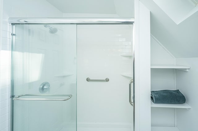 bathroom featuring walk in shower and vaulted ceiling