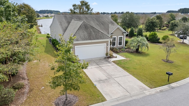 view of front facade featuring a front yard, a garage, and a water view