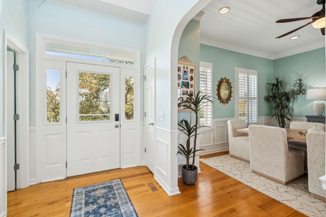 68 W 9th St Unit B, Folly Beach, SC 29439 - foyer featuring crown molding, light wood-style floors, ceiling fan, arched walkways, and a wainscoted wall