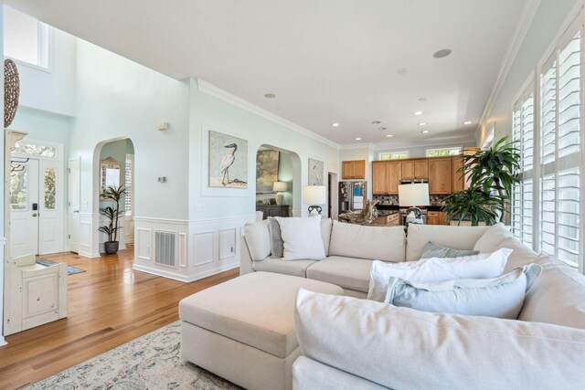 68 W 9th St Unit B, Folly Beach, SC 29439 - living room featuring arched walkways, ornamental molding, visible vents, and light wood-style flooring