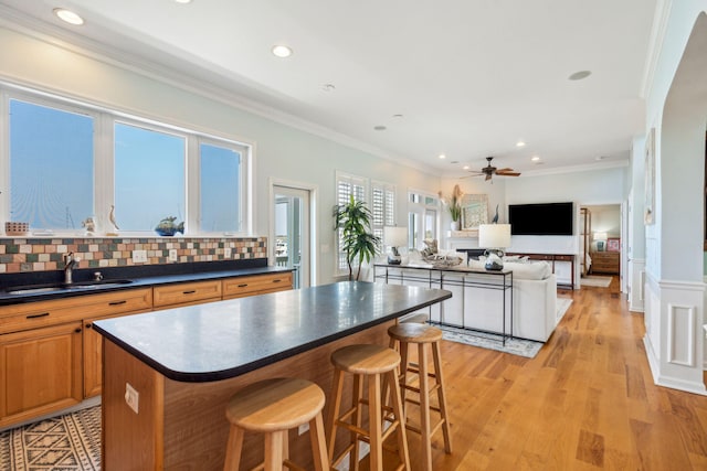 68 W 9th St Unit B, Folly Beach, SC 29439 - kitchen with dark countertops, crown molding, ceiling fan, and a sink