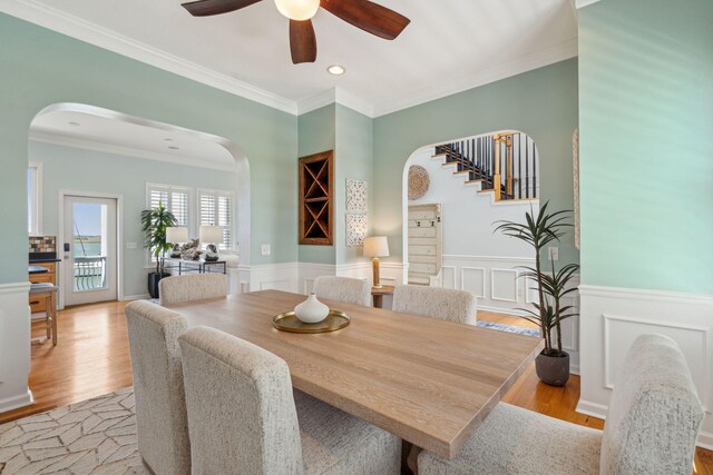 68 W 9th St Unit B, Folly Beach, SC 29439 - dining space with wood finished floors, a ceiling fan, arched walkways, crown molding, and wainscoting