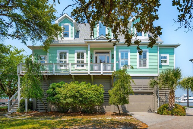 68 W 9th St Unit B, Folly Beach, SC 29439 - coastal home featuring an attached garage, aphalt driveway, and stairway