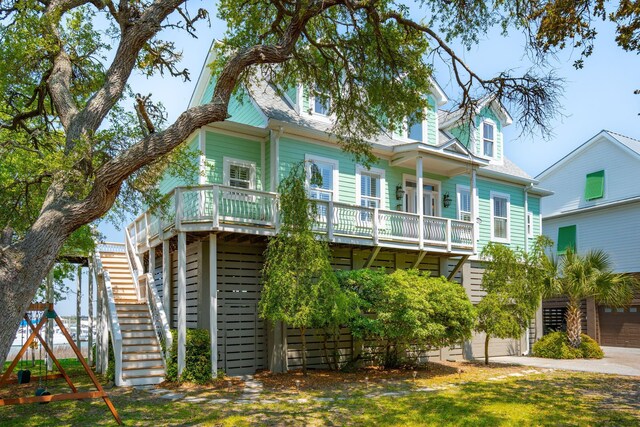 68 W 9th St Unit B, Folly Beach, SC 29439 - view of front of home with an attached garage, driveway, stairs, and a playground