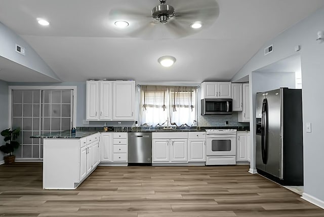 kitchen with white cabinets, appliances with stainless steel finishes, kitchen peninsula, vaulted ceiling, and ceiling fan