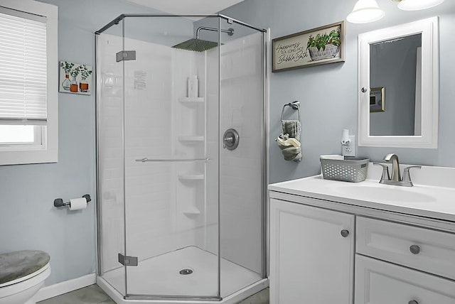 bathroom with toilet, an enclosed shower, and vanity