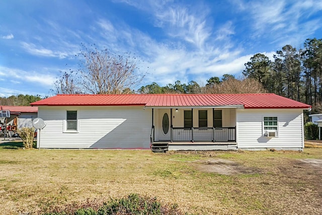 rear view of property featuring a porch and a yard