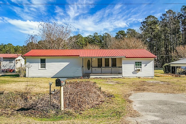 ranch-style house with covered porch and a front lawn