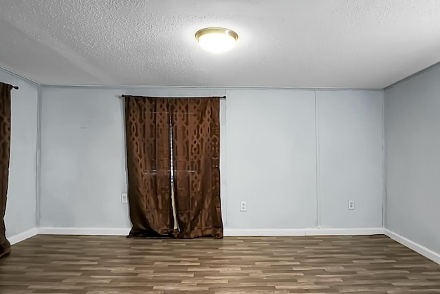 spare room with dark hardwood / wood-style floors and a textured ceiling