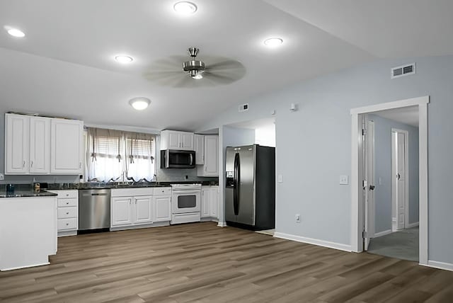 kitchen with ceiling fan, white cabinets, stainless steel appliances, and vaulted ceiling