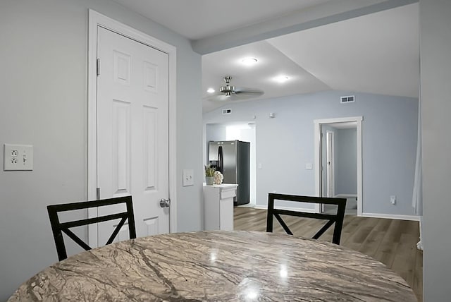 dining space featuring light hardwood / wood-style flooring and vaulted ceiling