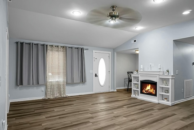 foyer entrance with ceiling fan, wood-type flooring, and lofted ceiling