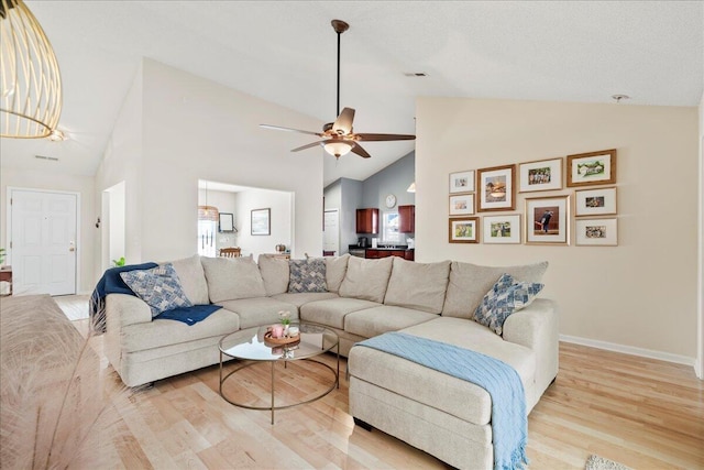 living room featuring high vaulted ceiling, ceiling fan, and light hardwood / wood-style flooring