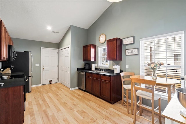 kitchen featuring sink, high vaulted ceiling, dishwasher, and light wood-type flooring