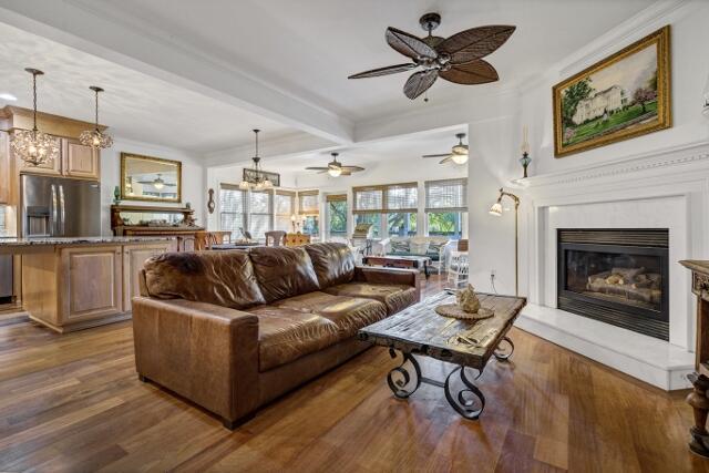 living room featuring beamed ceiling, dark hardwood / wood-style floors, and a healthy amount of sunlight