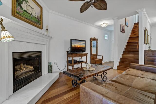 living room with crown molding, hardwood / wood-style floors, and ceiling fan