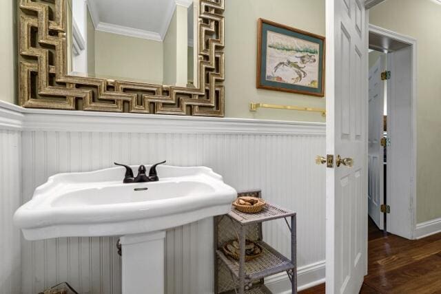 bathroom featuring ornamental molding, sink, and hardwood / wood-style floors