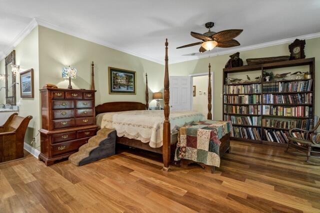 bedroom featuring crown molding and light hardwood / wood-style floors