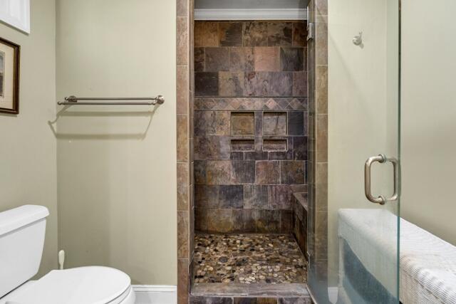 bathroom featuring toilet and an enclosed shower