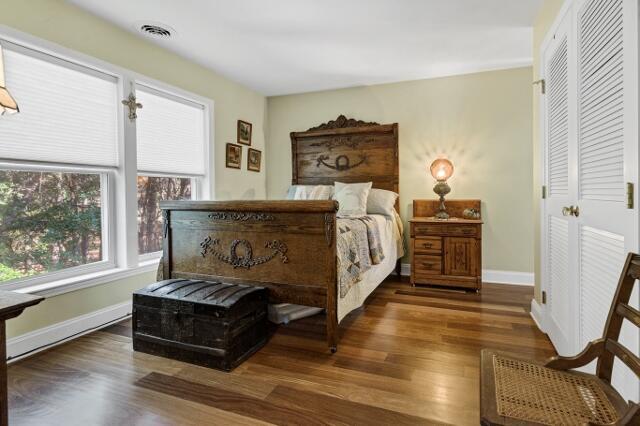 bedroom with dark hardwood / wood-style floors and a closet