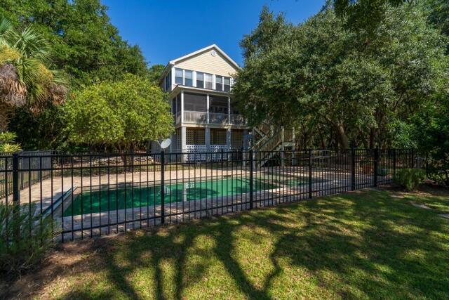 view of swimming pool featuring a sunroom, a yard, and a patio area