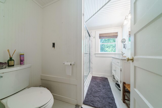 bathroom with vanity, toilet, and a shower with door