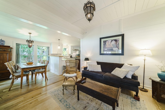 living room featuring a chandelier, light hardwood / wood-style floors, wooden ceiling, and sink