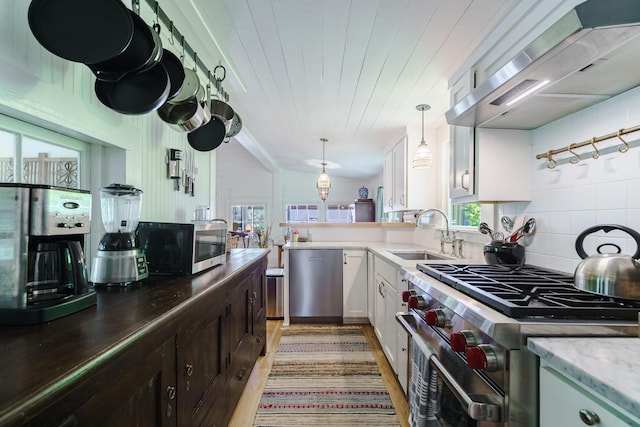 kitchen featuring pendant lighting, white cabinets, sink, appliances with stainless steel finishes, and extractor fan