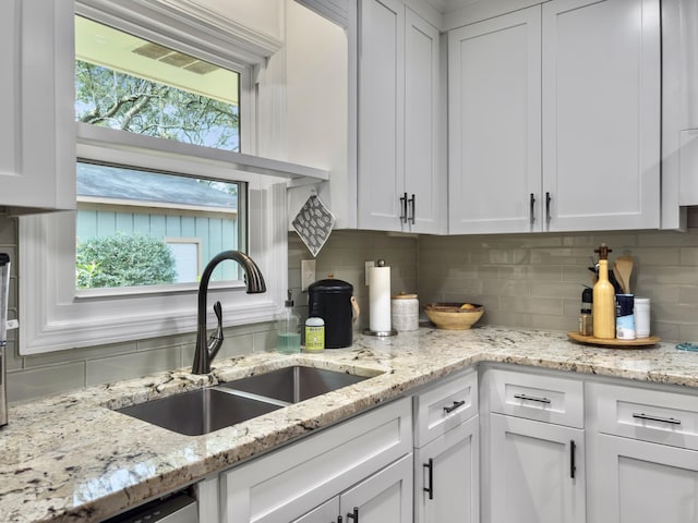 kitchen featuring white cabinets and a sink