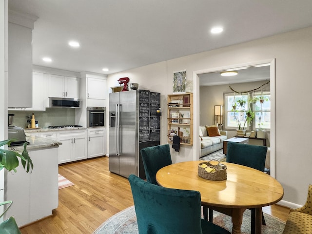 dining room with recessed lighting and light wood-style floors