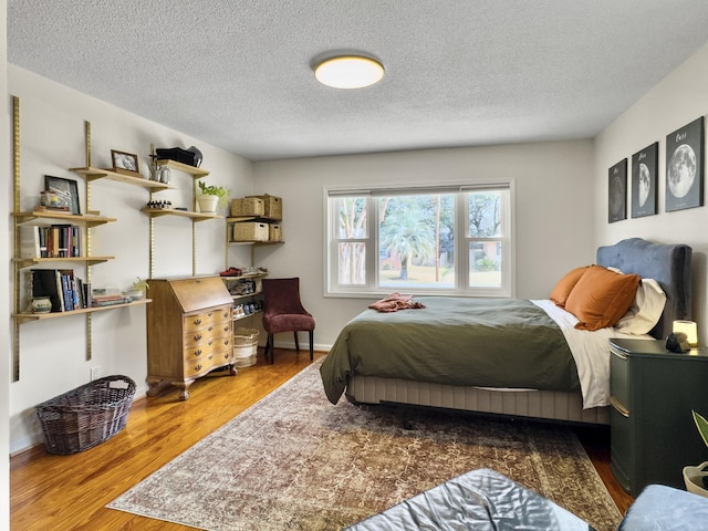 bedroom with a textured ceiling and wood finished floors