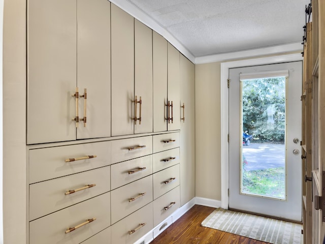 doorway featuring baseboards, dark wood finished floors, and a textured ceiling